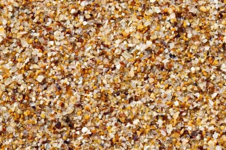 Textura de arena de mar hecha de conchas y piezas de piedra.  Textura fluida
