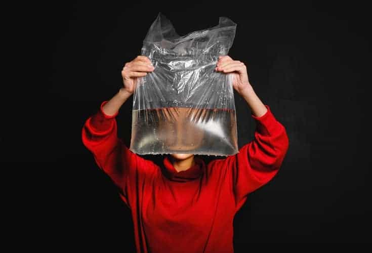 mujer sosteniendo una bolsa de plástico con agua